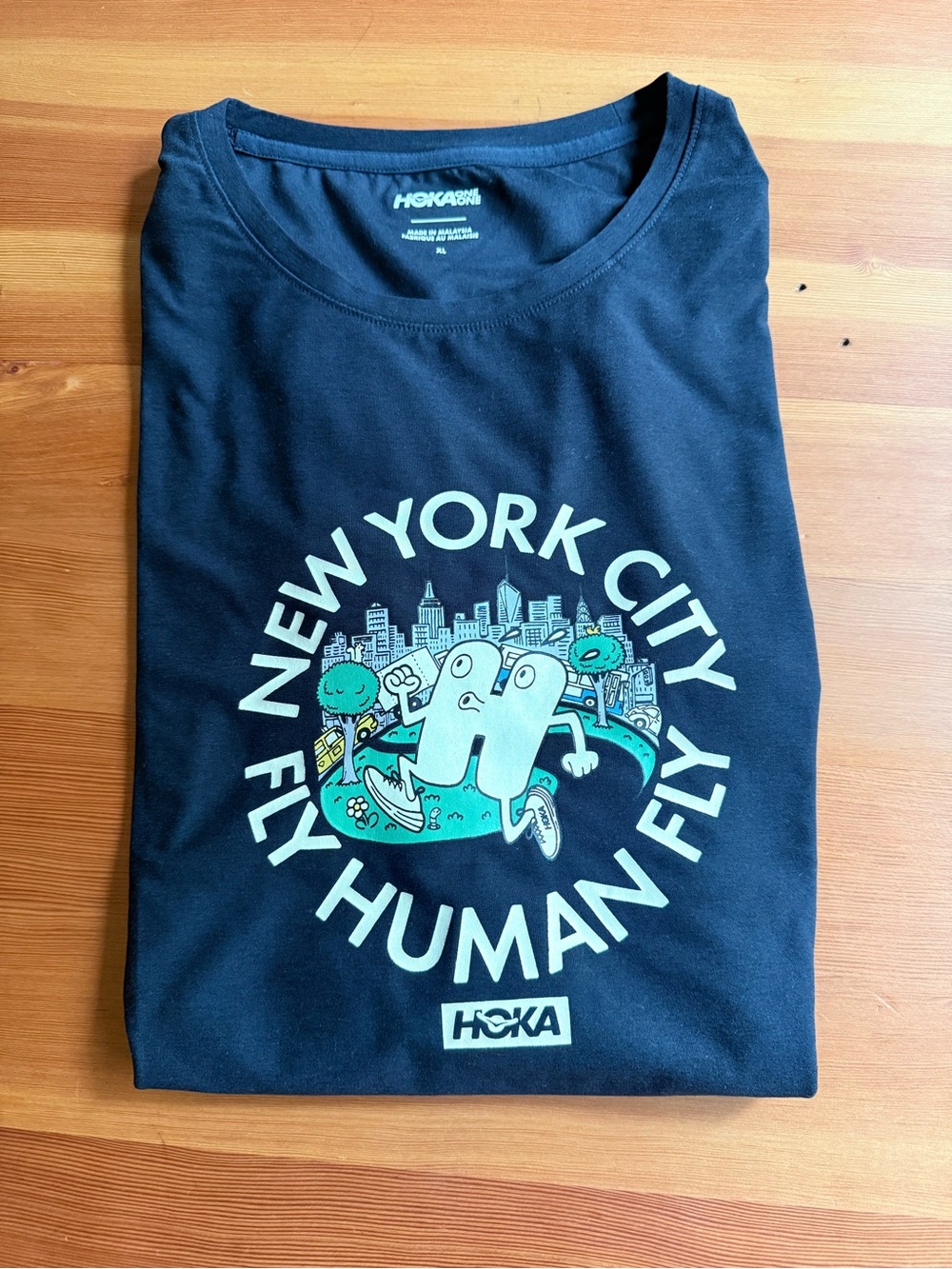 Hoka One One Black Tee with Teal and White New York City Fly Human Fly Graphic
